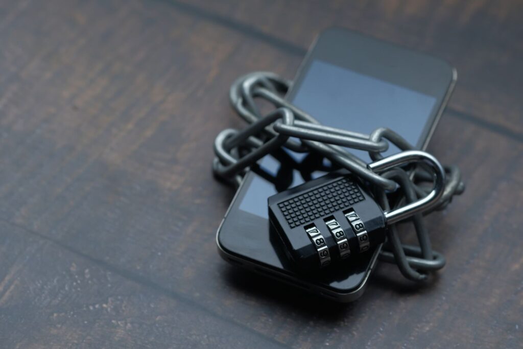 Smartphone wrapped in a chain and padlock representing strong account security