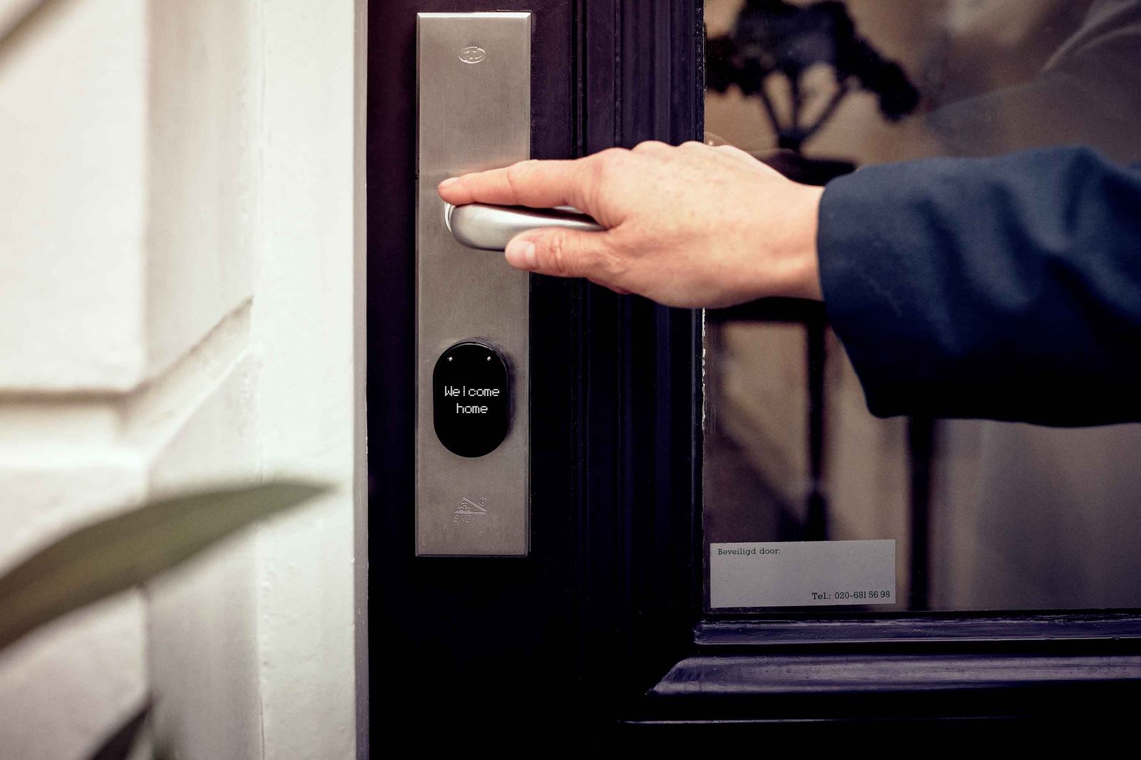 Person opening an office door with a smart lock and digital keypad display
