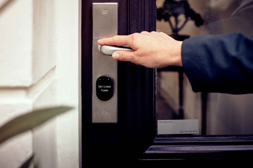 Hand opening a front door fitted with a smart lock