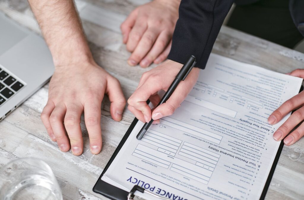 Business owner and advisor reviewing an insurance policy application at a desk