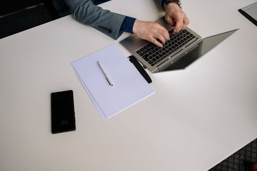 Business professional working at a laptop in a clean office reviewing customer records