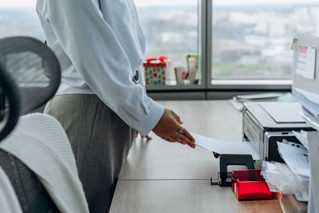 Office worker collecting a document from a printer in a bright Central Florida office