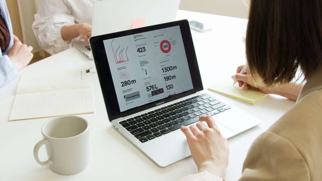Employee working on a laptop with business data on the screen in a bright office