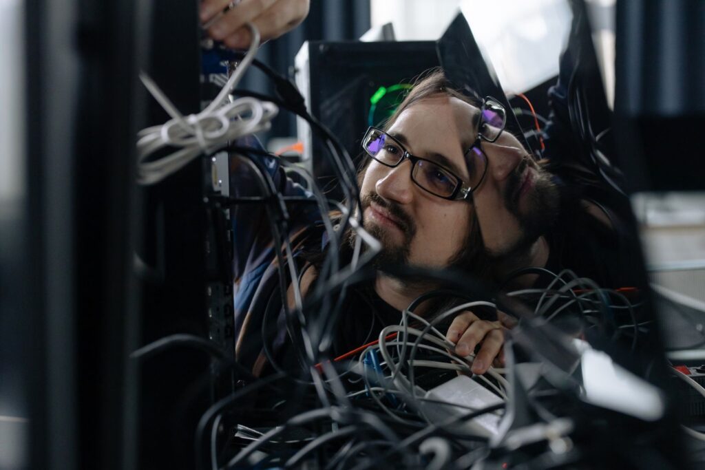 Technician working on network cables inside a small business equipment rack