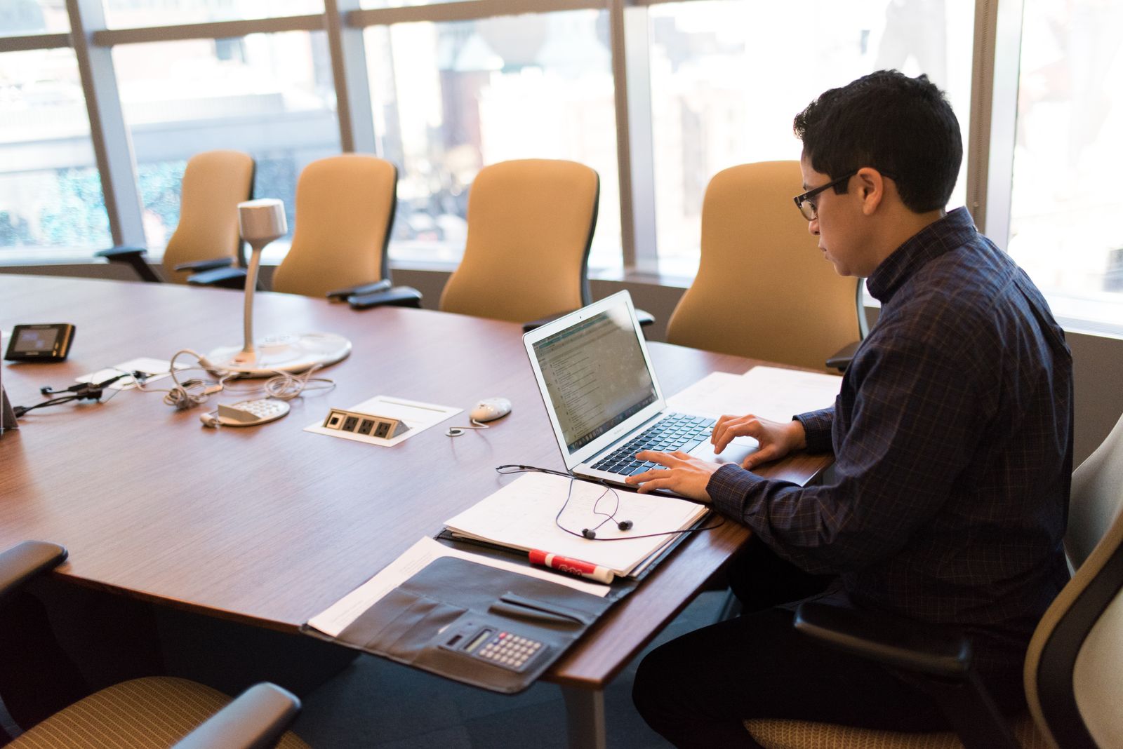 Employee working on a laptop at an office conference table