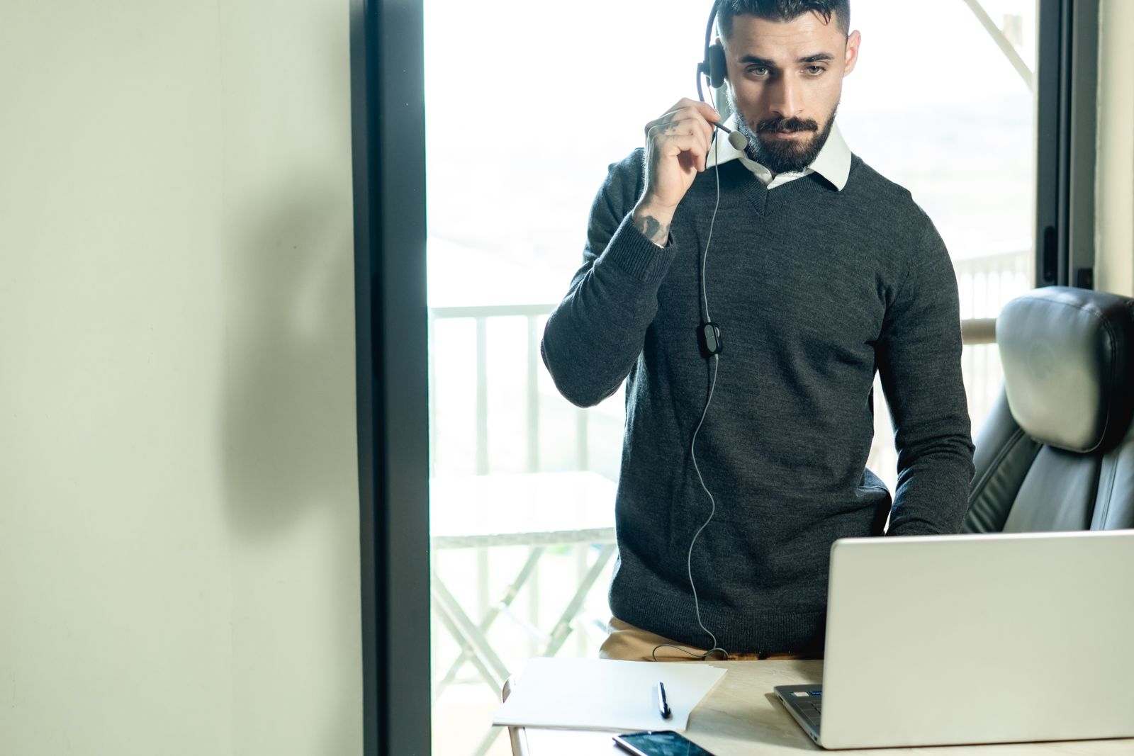 Technician wearing a headset providing remote IT support from a laptop