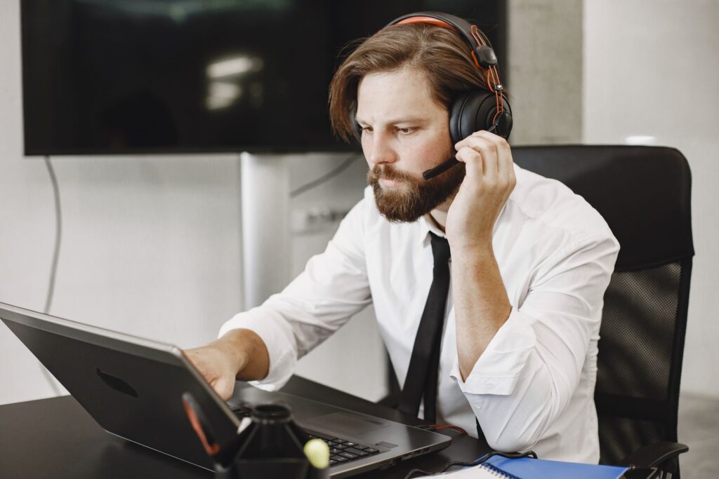 IT technician wearing a headset providing remote IT support in Florida from a laptop