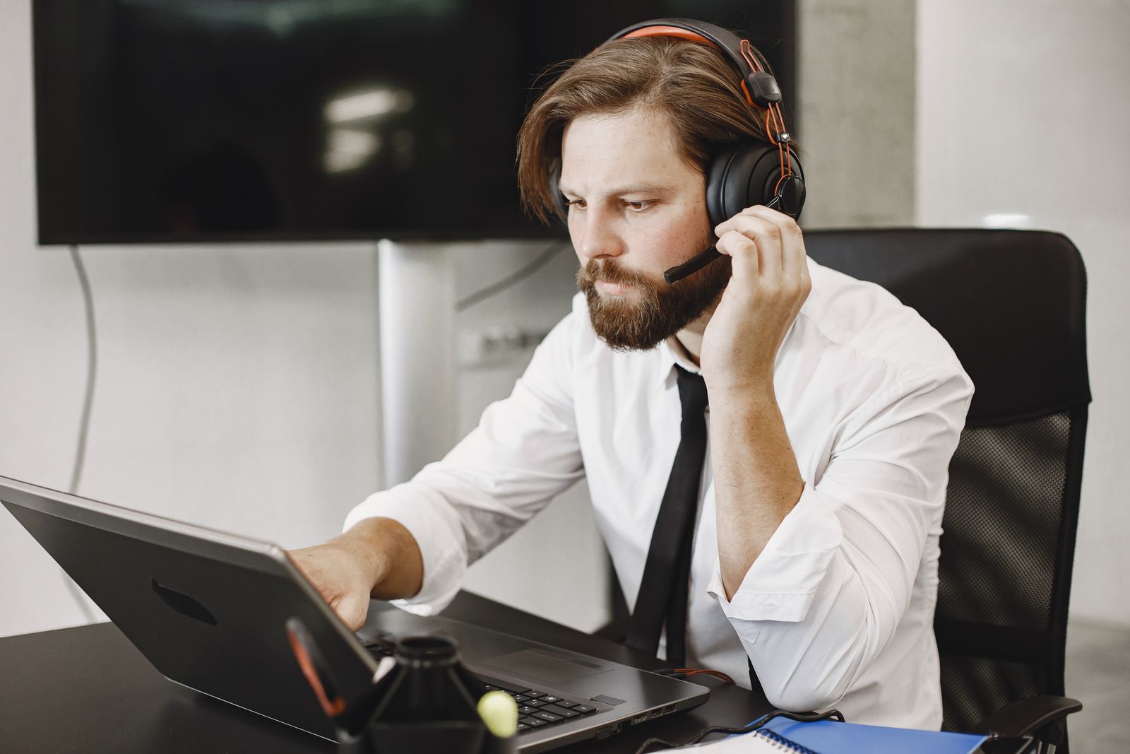 IT technician wearing a headset providing remote IT support in Florida from a laptop