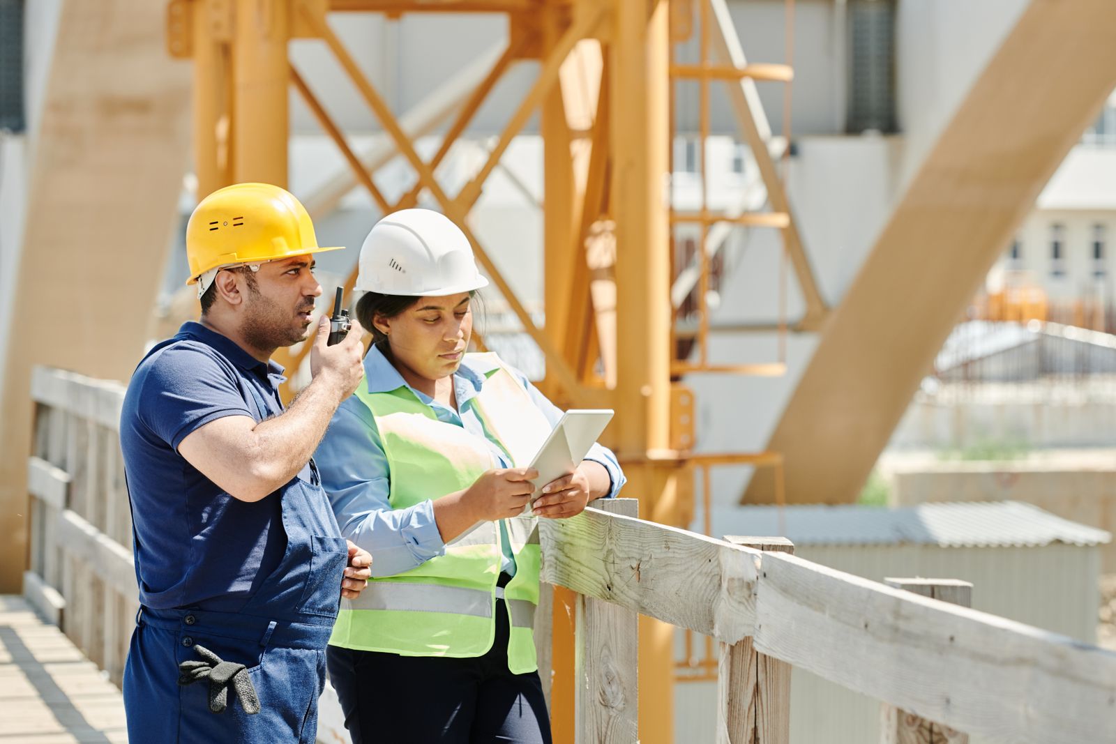 Construction workers on a job site reviewing plans on a tablet in Central Florida