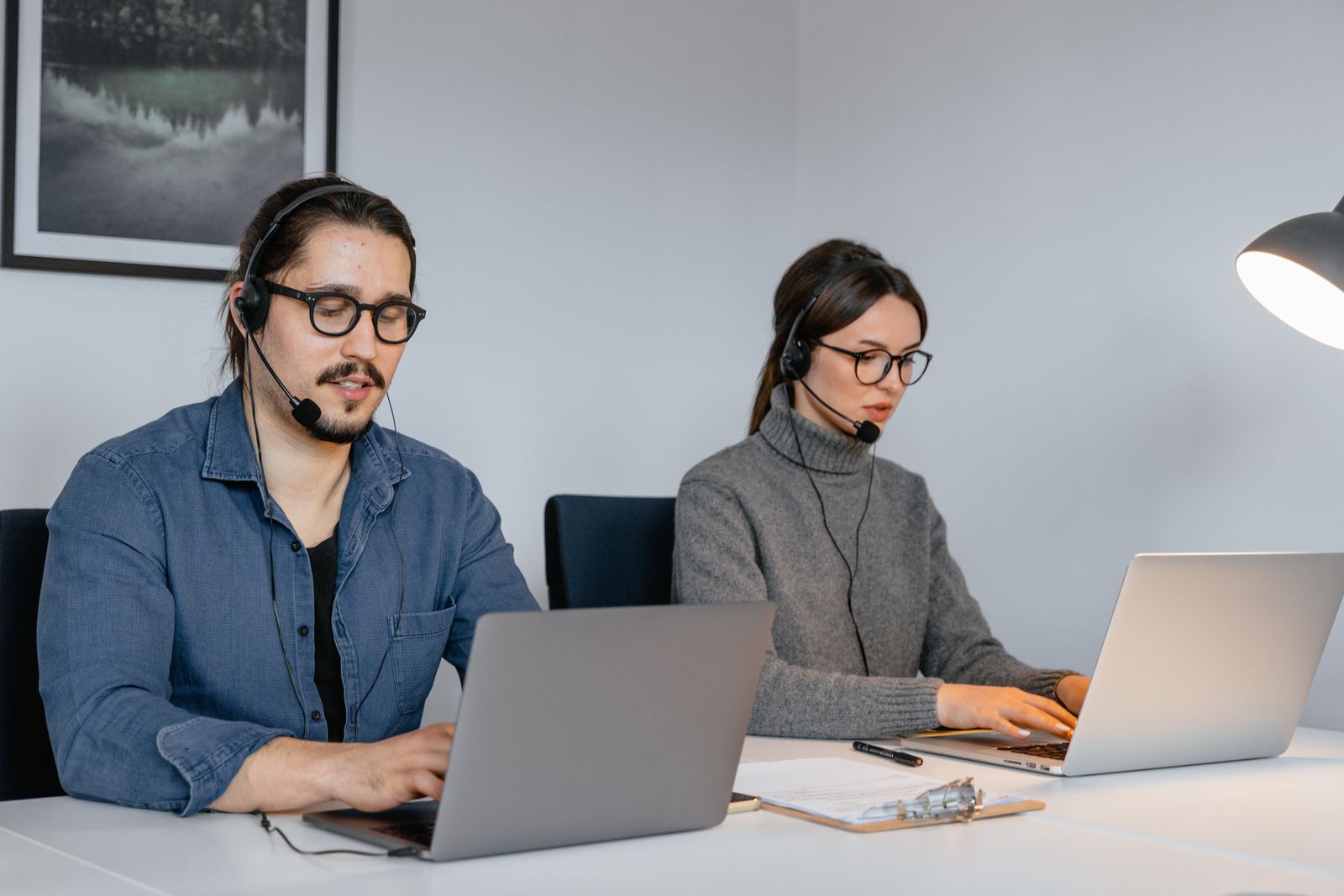 Remote IT support technicians in Winter Park FL helping clients on laptops with headsets