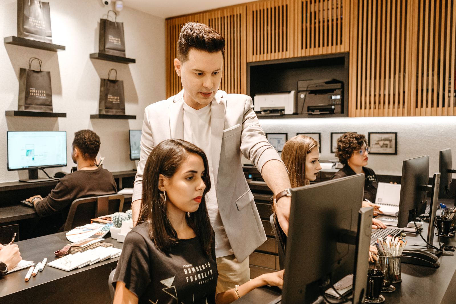 Tech support specialist helping a small business employee at her office computer