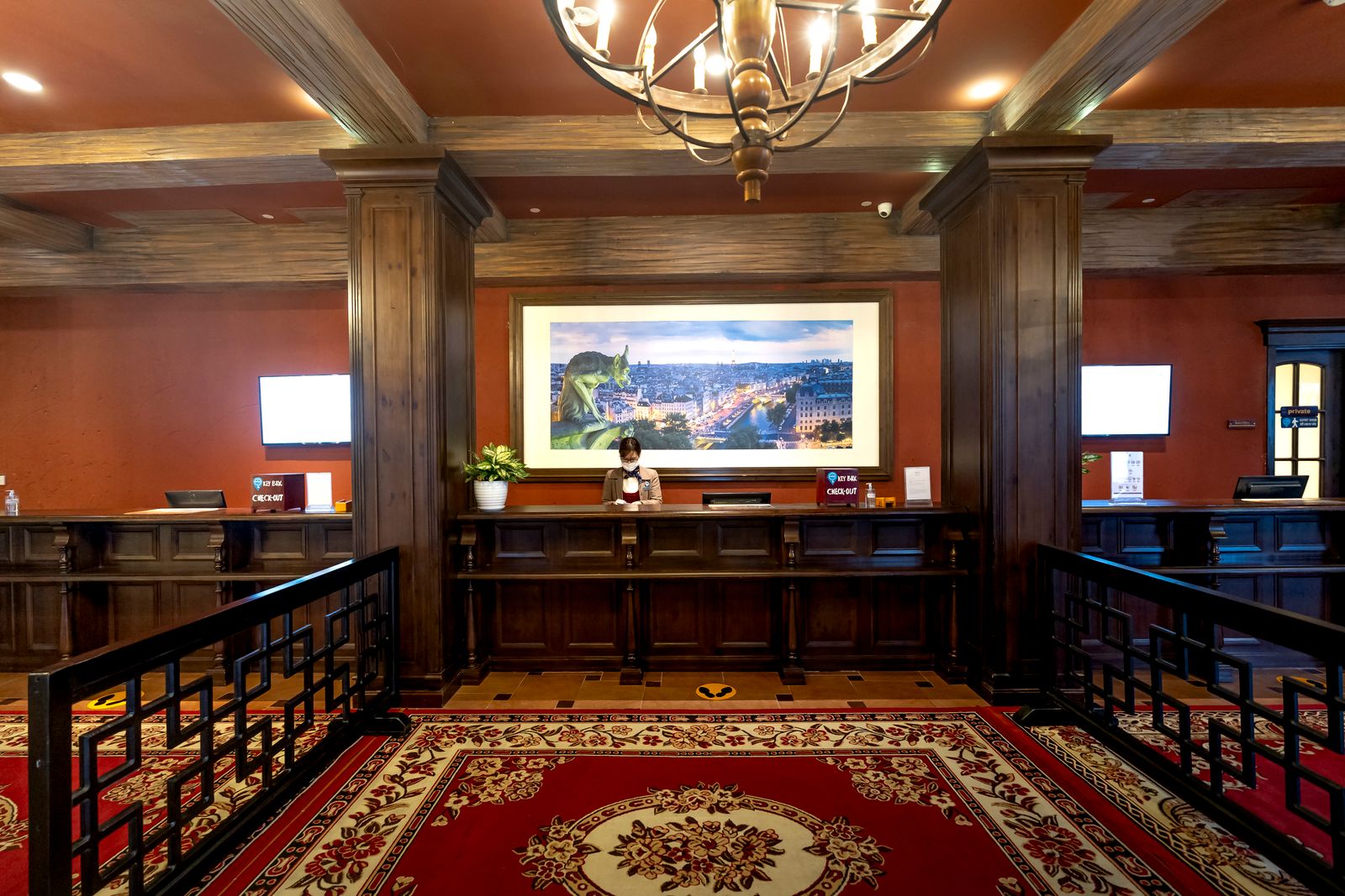 Hotel front desk with computer screens in a warmly lit lobby