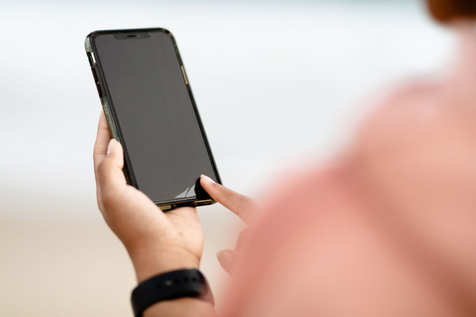 Person holding a smartphone, checking it for signs of a phone virus