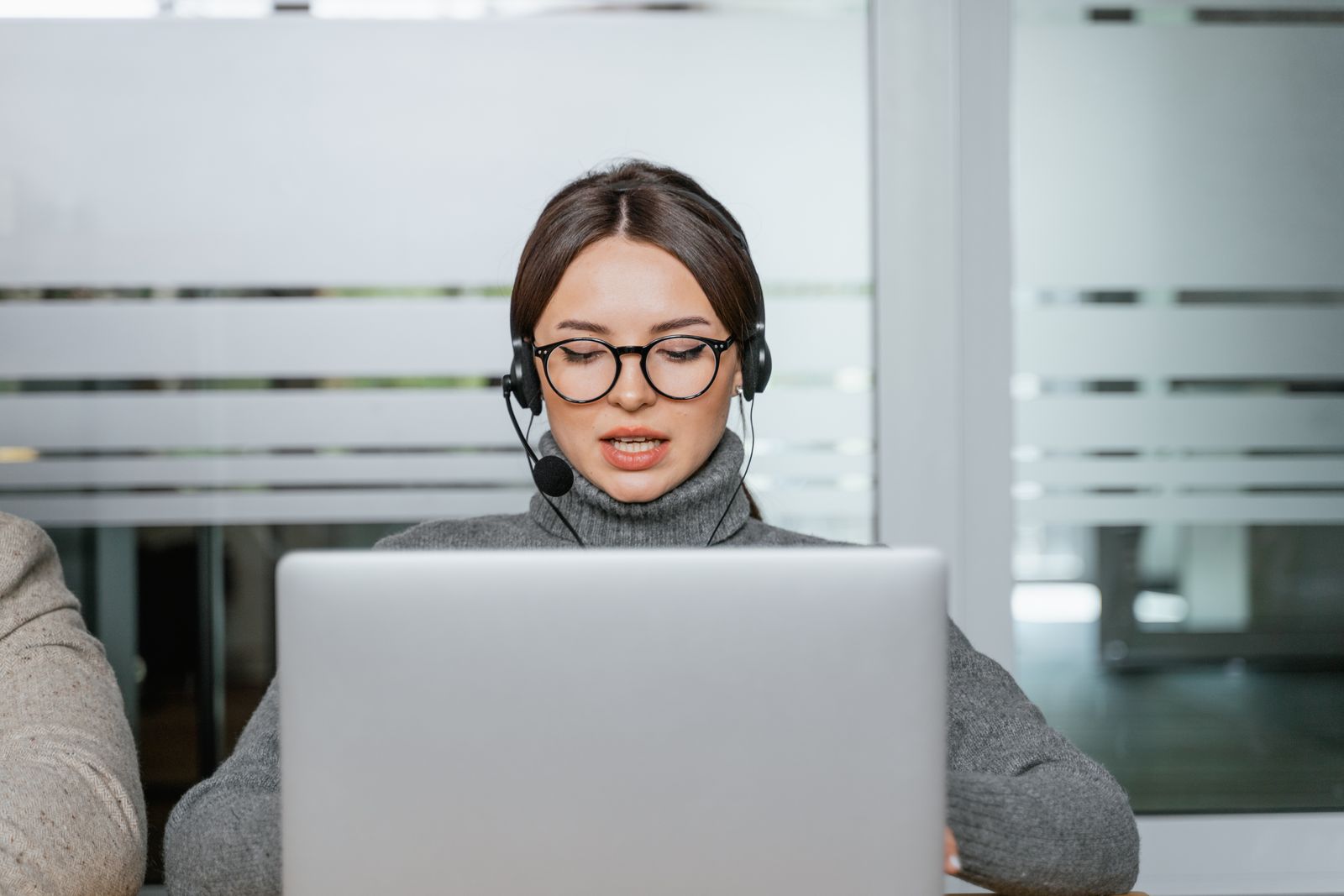 Remote IT assistance technician with headset helping a client on a laptop
