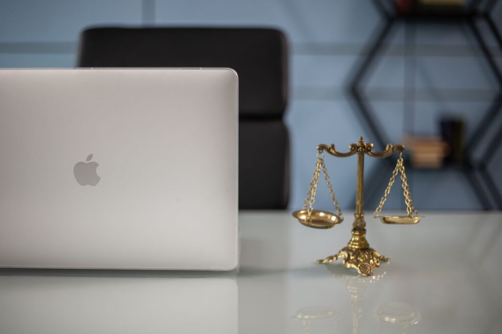 Laptop and brass scales of justice on a law office desk