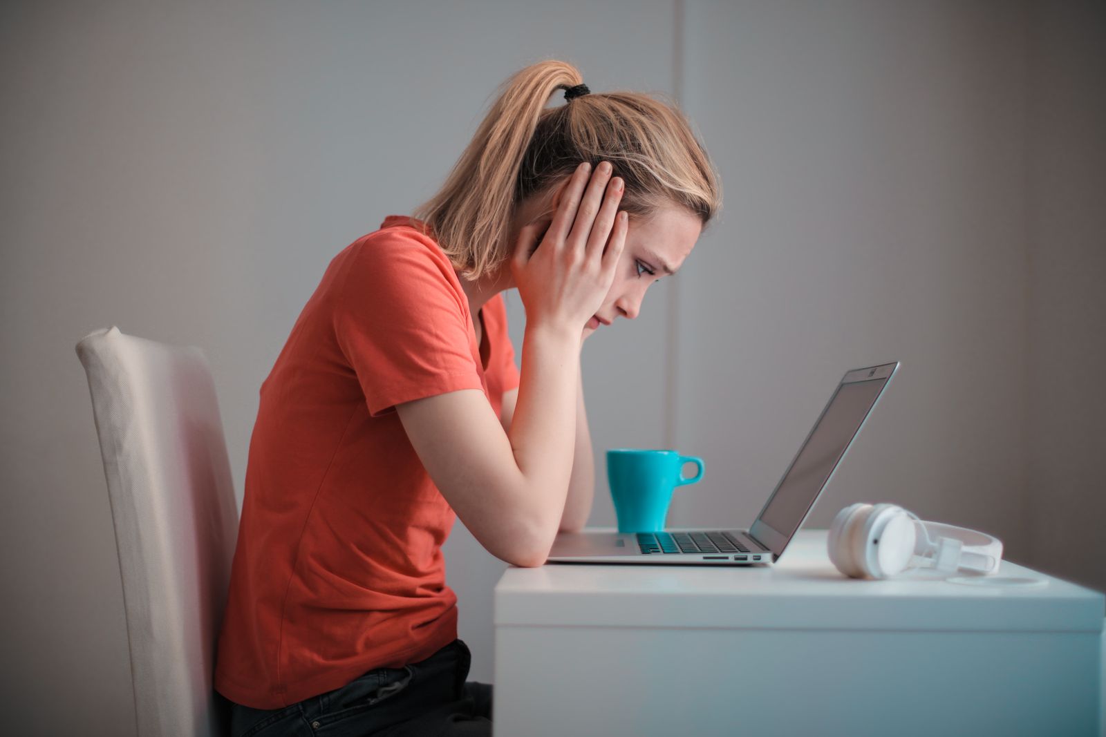 Worried woman looking at a laptop after a pop up says her computer is infected